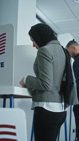 Female-American-soldier-comes-to-vote-in-booth-in-polling-station-office.-National-Election-Day-in-the-United-States.-Political-races-of-US-presidential-candidates.-Concept-of-civic-duty.-Dolly-shot.