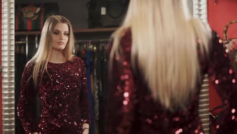 woman trying on a sequined dress in a dressing room.