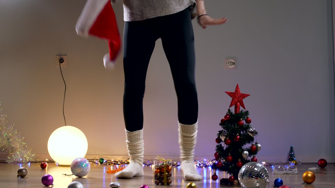 키 소녀가 산타 모자를 입고 춤을 추고 음악을 듣고 리을 즐기고