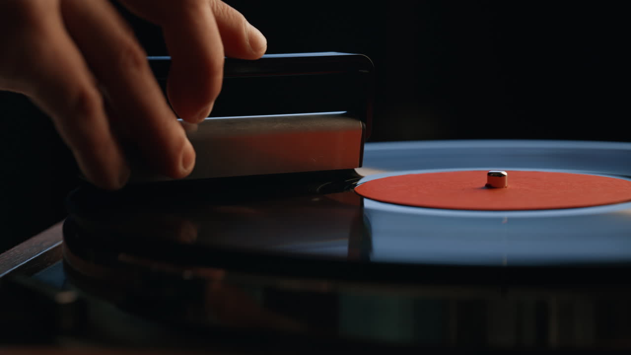 Hand cleaning vinyl disc in dark room closeup. Unrecognizable man using brush