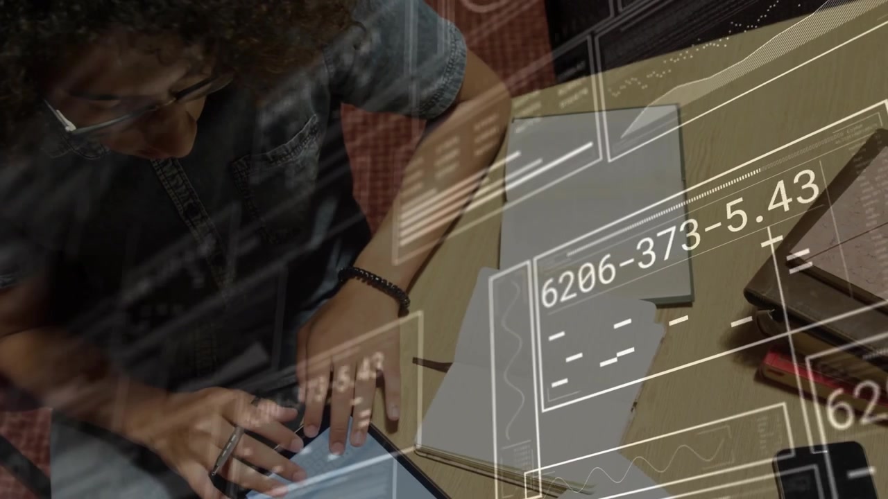 Man tapping tablet and scrolling at table, activating HUD overlays and updating charts for business