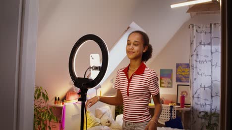 teenage girl recording a video tutorial in her bedroom