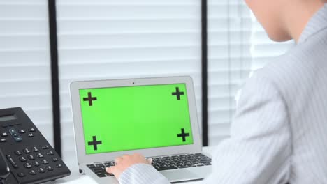 close up business woman working in office on green screen computer.