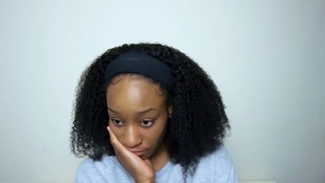 young student visibly bored whilst looking directly into camera during remote lecture