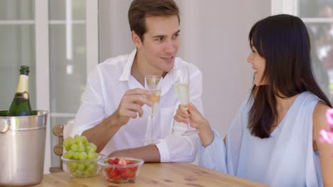 Cheerful-couple-toasting-champagne