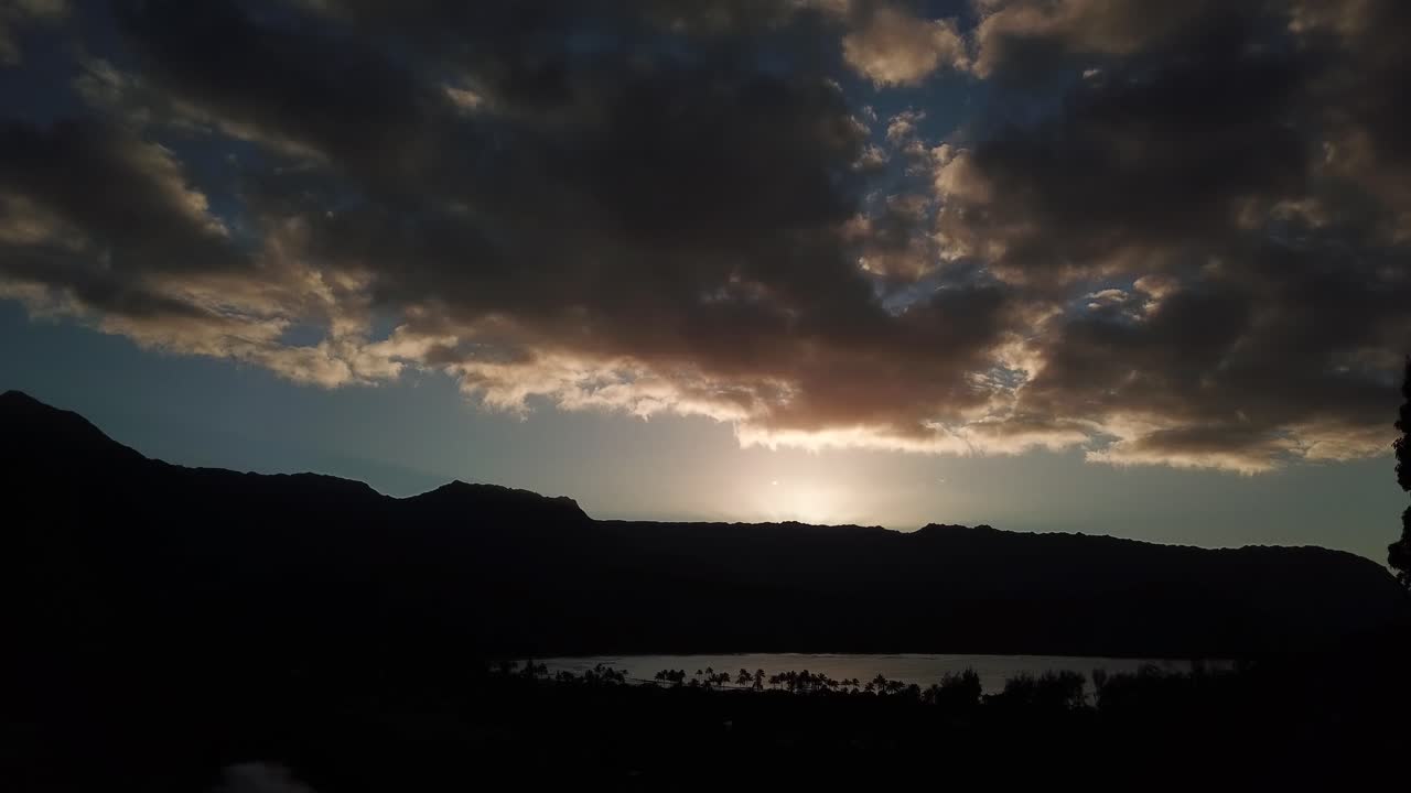 Vista de dron descendiendo muy lentamente de la Bahía de Hanalei al atardecer con nubes en Kauai, Hawái