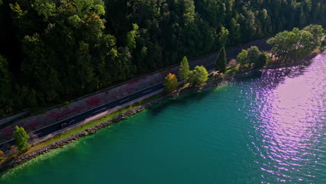 Drone-Volando-A-Lo-Largo-De-La-Orilla-Del-Lago-Attersee-En-Austria-Además-De-Una-Carretera-Estrecha