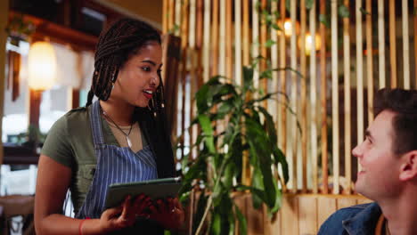 waitress taking order from customer in cafe