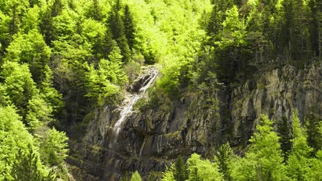 Forest-waterfall-cascading-down-rock-face,-Pyrenees