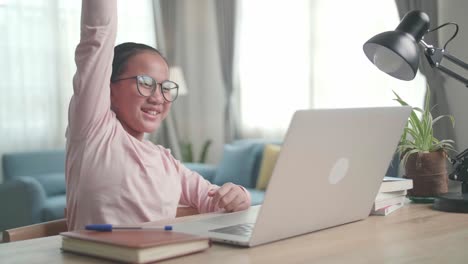 young asia girl student celebrating with laptop computer at home, teenage girl learning online from laptop