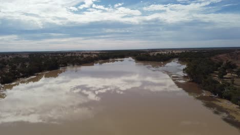 volando sobre un lago en el interior de australia mostrando los reflejos de las nubes
