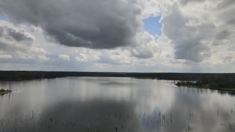 Drohne-Fliegt-über-Offenes-Wasser-Mit-Spiegelung-Von-Wolken-Im-Wasser