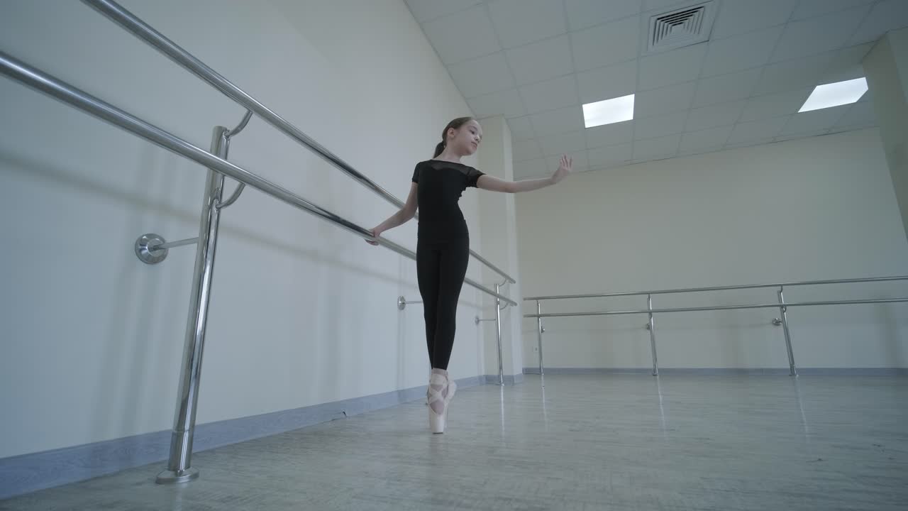 joven bailarina en la lección de estudio. rendimiento de entrenamiento. postura de ejercicio de estiramiento. bailarina practica técnica de equilibrio. elegancia clásica fitness.