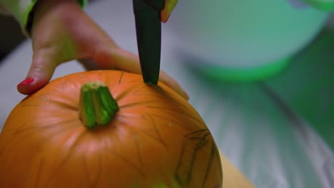 starting to carve pumpkin indoors with sharp knife slowmotion