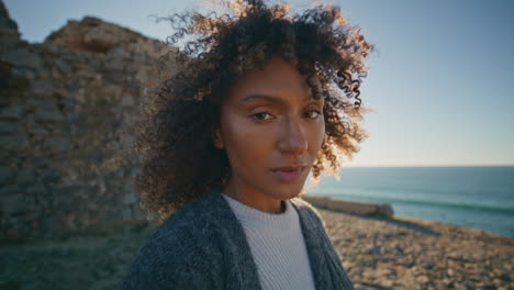 Windy hair model posing at coast portrait. Travel girl looking camera closeup