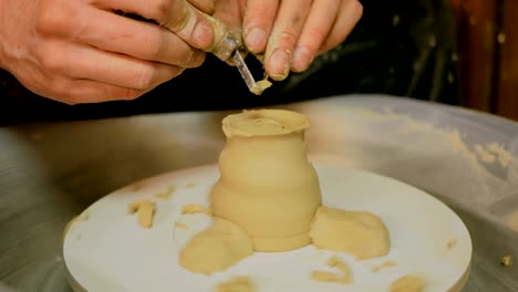 professional potter shaping mug with special tool in pottery workshop