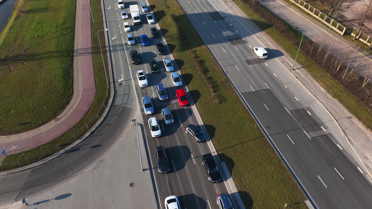 Many cars are moving on one side of the road, while the other side is almost empty. City life, Klaipeda.