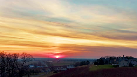aerial drone hyperlapse, timelapse of colorful sunset, jet chemtrail, contrail visible in sky