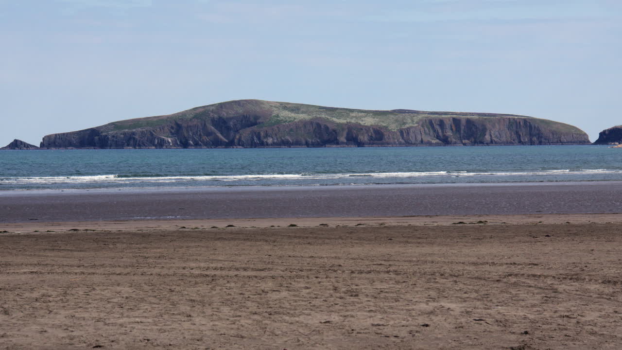 Long shot of Y Gwbert at Poppit Sands Beach, Teifi Estuary,