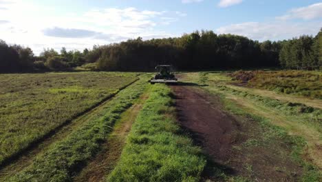 vista frontal aérea de una cosechadora cortando hierba en un campo verde