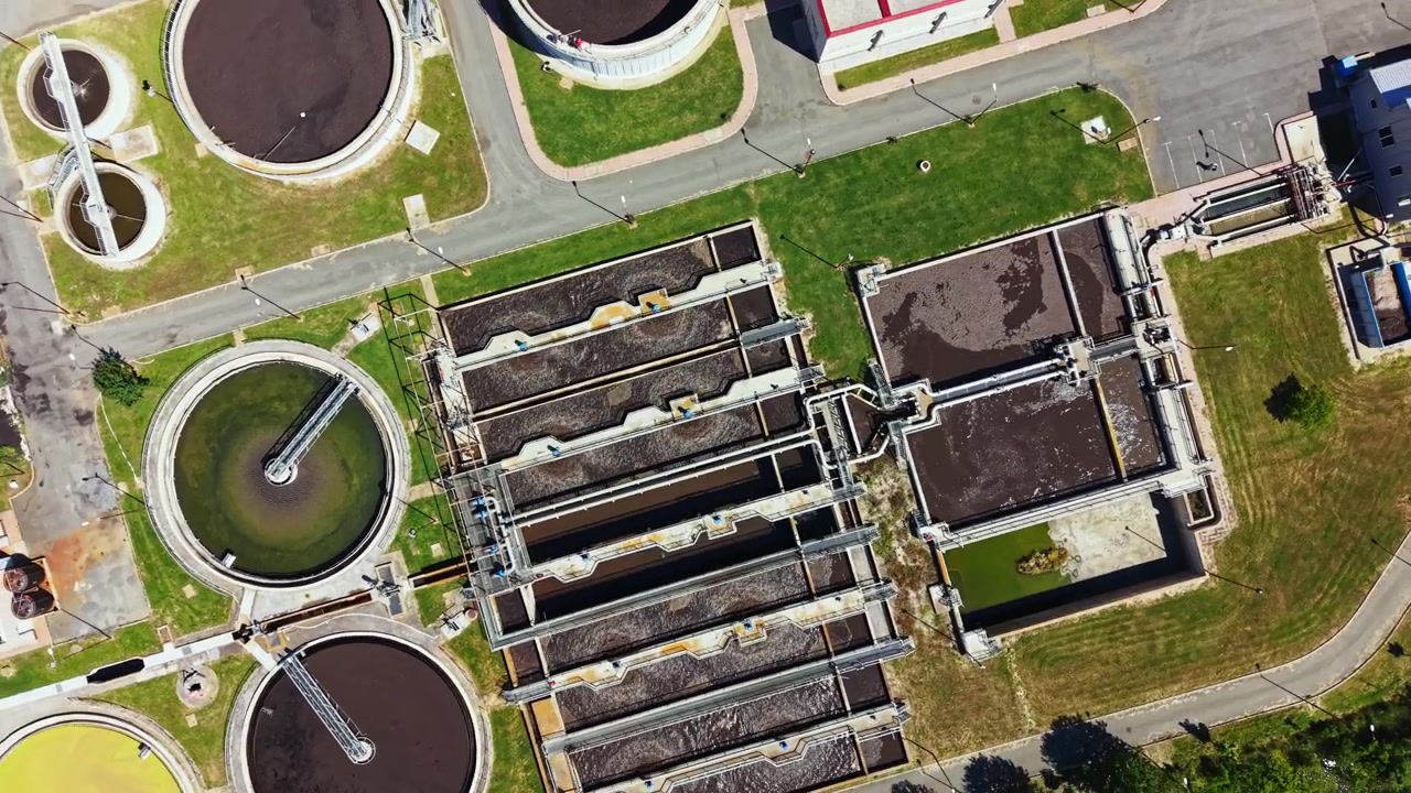 Water treatment facility shows various stages of waste processing and management at a large wastewater treatment plant during daytime