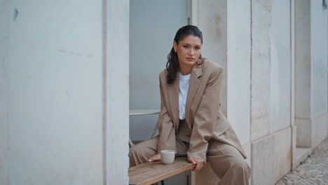 calm woman posing coffee house open air in elegant suit. beautiful businesswoman