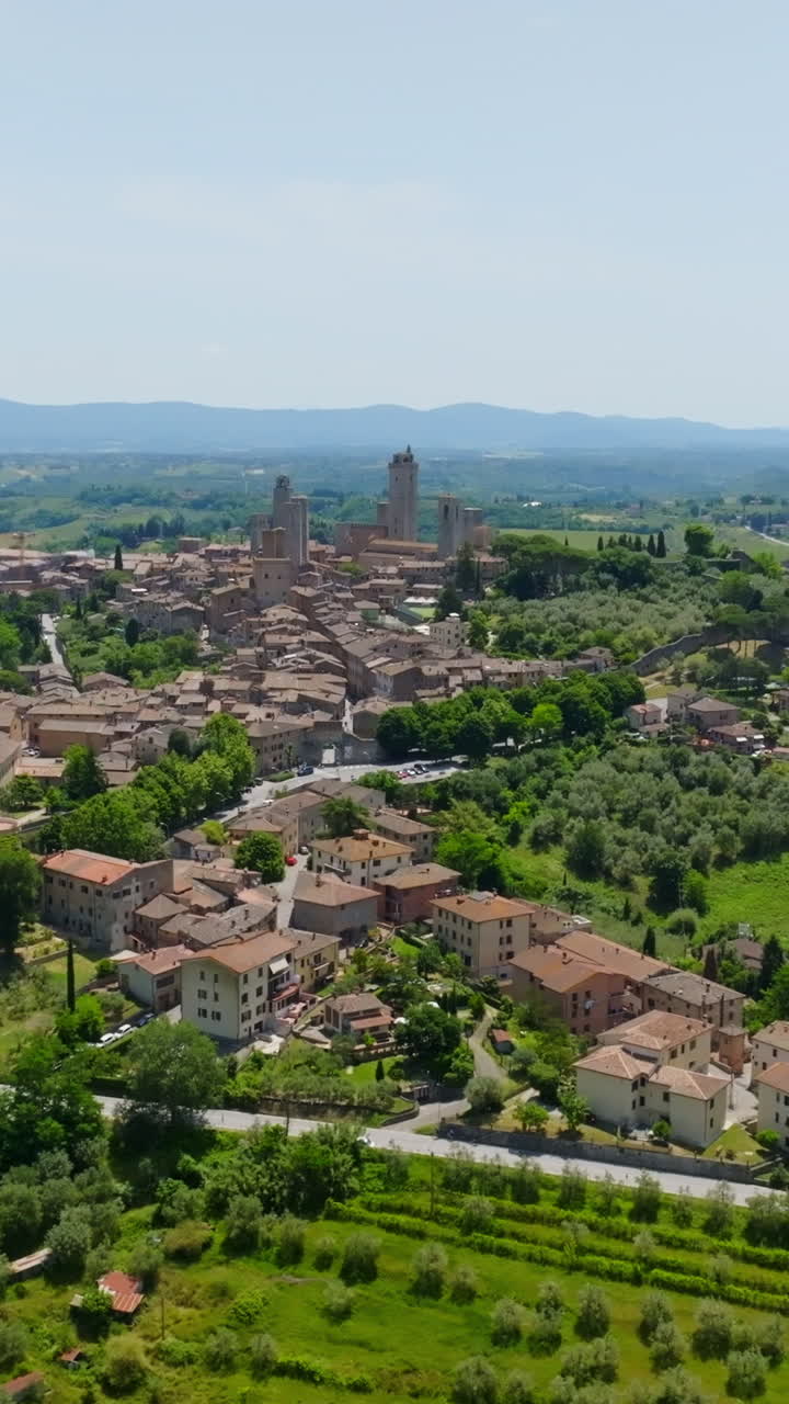 Vertical drone shot around the San Gimignano town, summer day in Tuscany, Italy