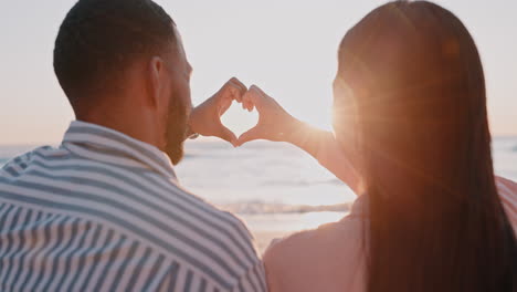 couple, heart and hands at beach in sun