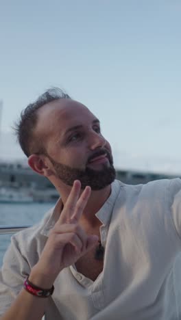 Man on a boat making a peace sign