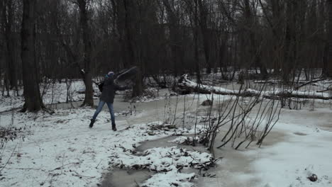 boy teenager taking away used tire from the way in winter park