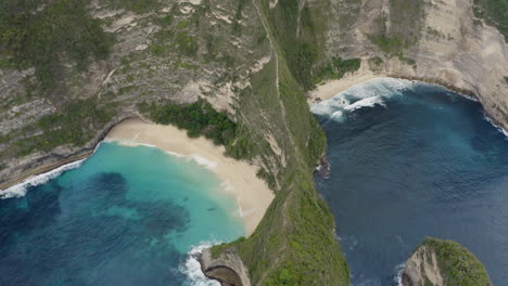 bird eye view of kelingking beach with steep cliffs and waves crushing ashore, nusa penida, bali, indonesia