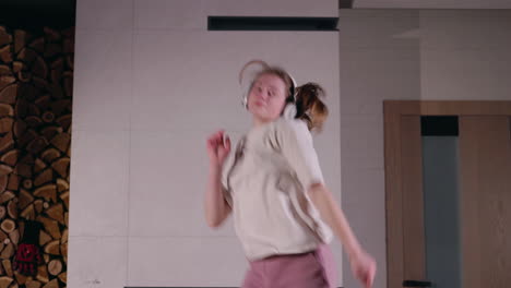 mujer bailando en casa con auriculares