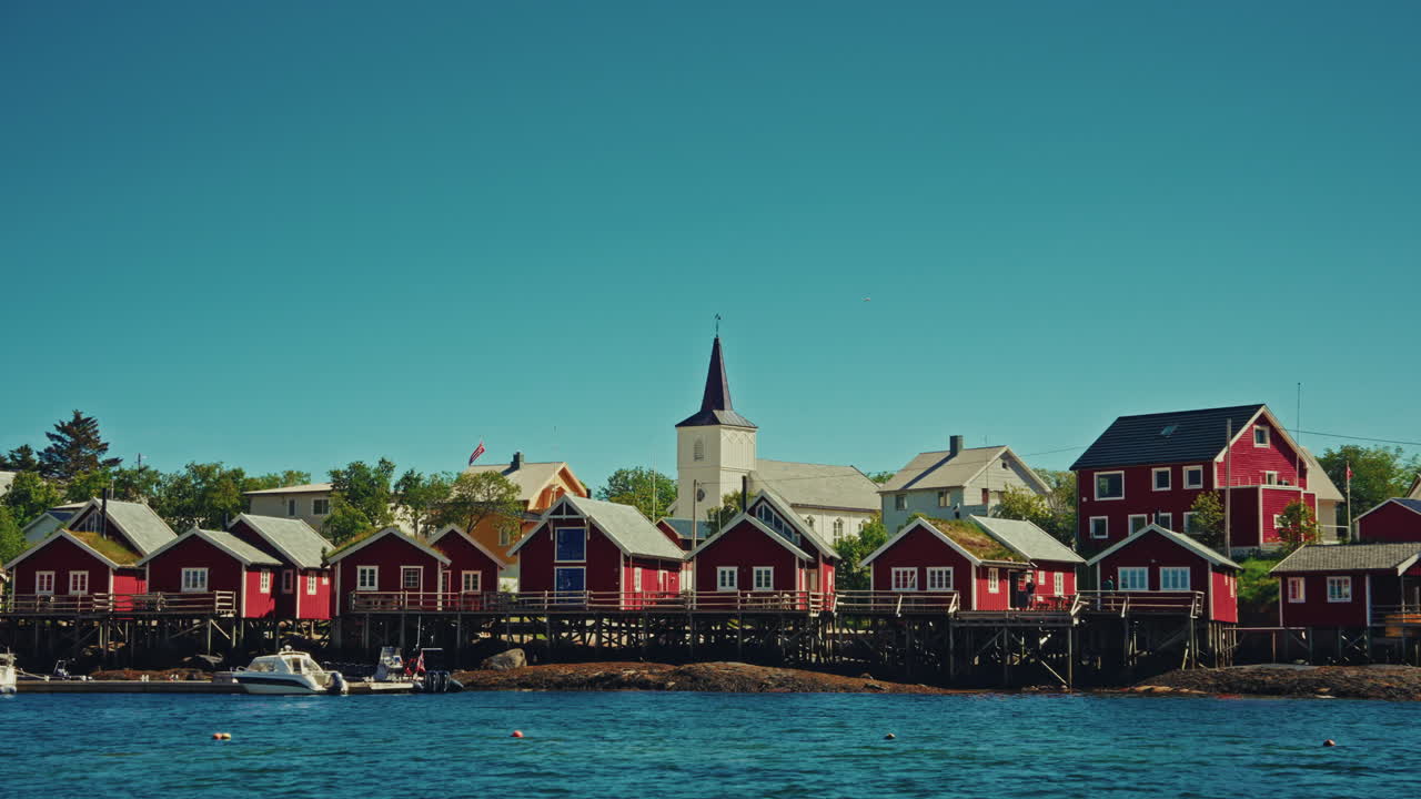 Bout tour around small local Norwegian town. View of the red wooden fishermen cabins.