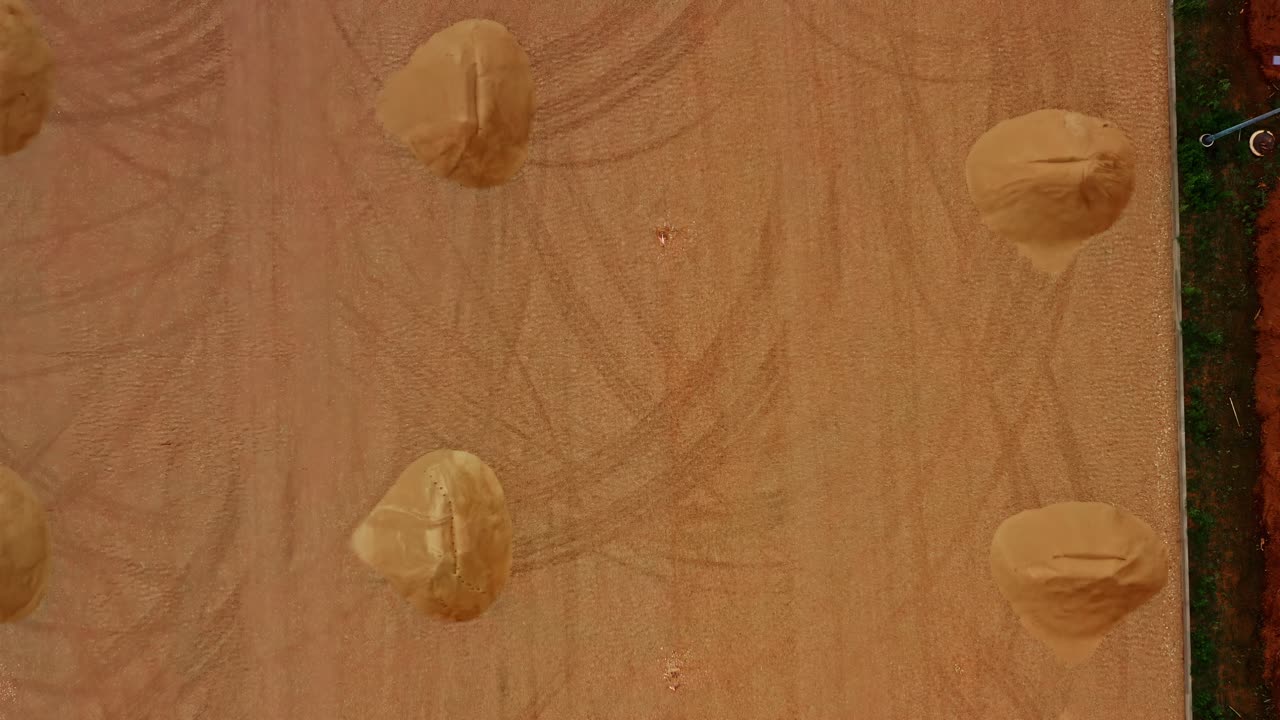 Baustelle mit mehreren Sandhaufen und Bodenmarkierungen von oben