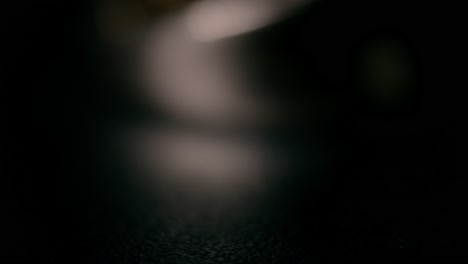 detailed macro shot of intertwined golden rings glinting on a dark surface, evoking elegance and intimacy. warm, low lighting emphasizes textures and reflections