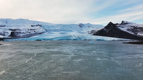 vista aérea de un glaciar con formaciones de hielo con textura, en islandia, al atardecer
