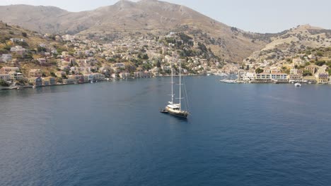 aerial orbit around a large sail boat, bay of symi, greece, scenic panorama