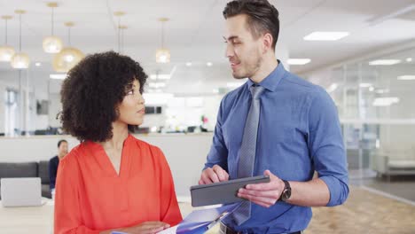 Group-of-diverse-business-people-holding-documents-and-talking-in-office,-slow-motion