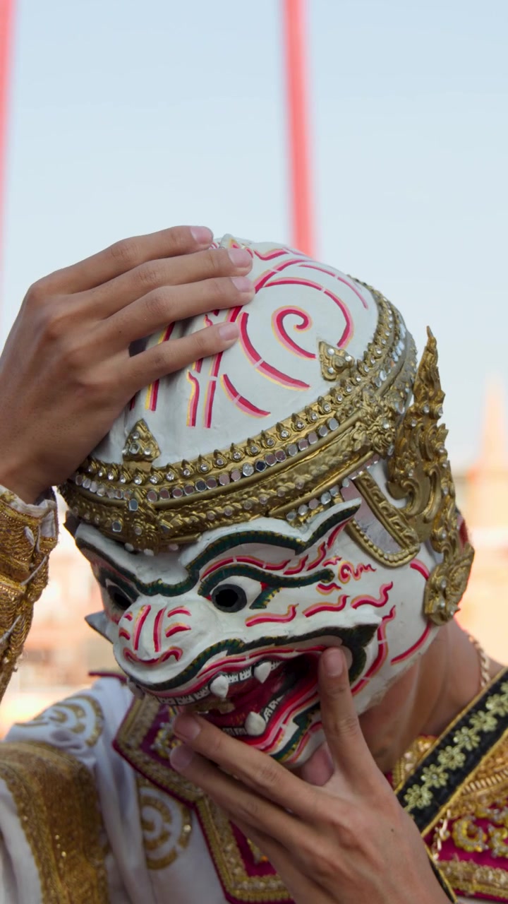 Primo piano di un ballerino che indossa un costume tradizionale e si mette una maschera
