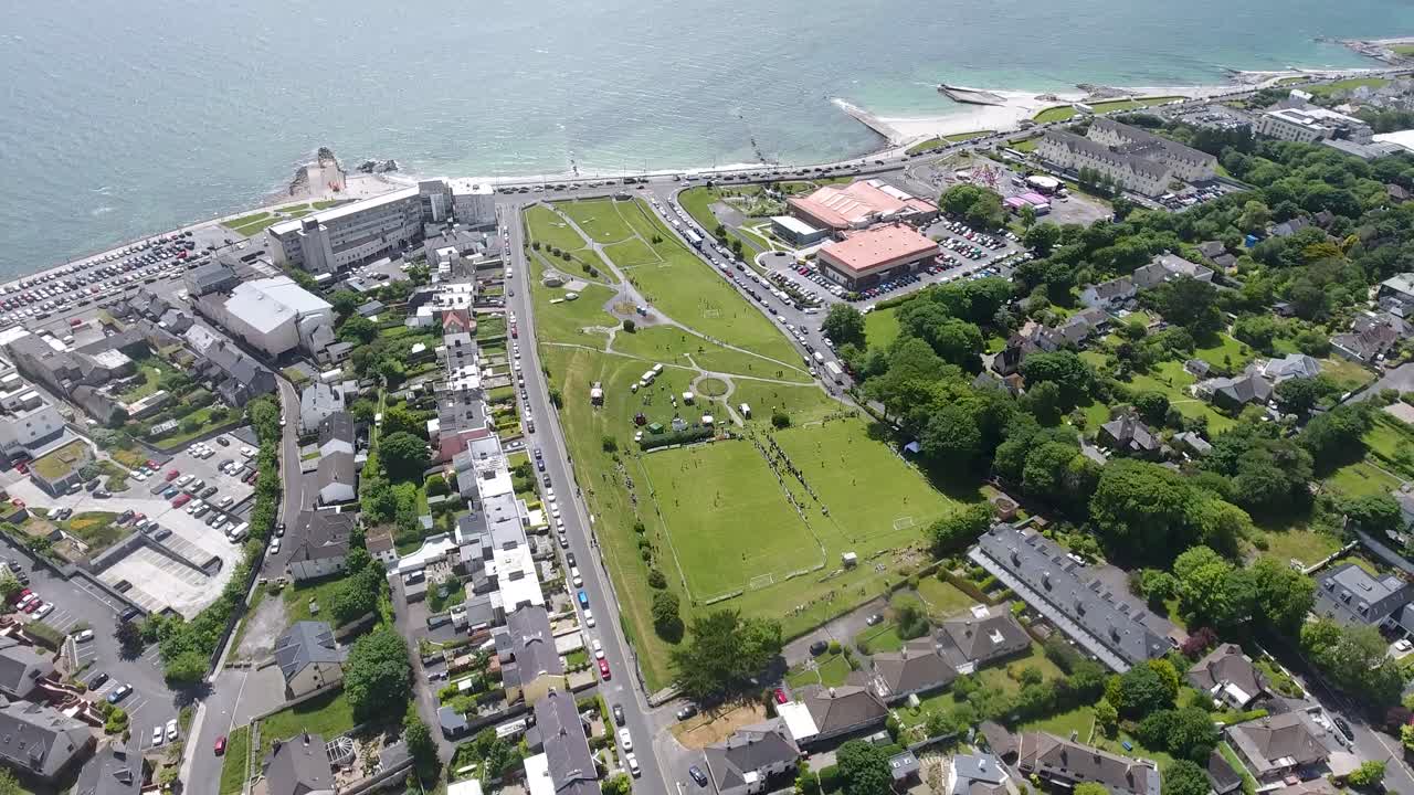 Ascending drone shot above Salthill Park in Galway with the sea and beach  in the background.