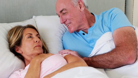 Happy-senior-couple-interacting-with-each-other-on-bed