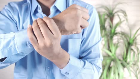 man holding wrist, showing pain