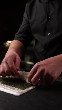 sushi chef preparing sushi rolls