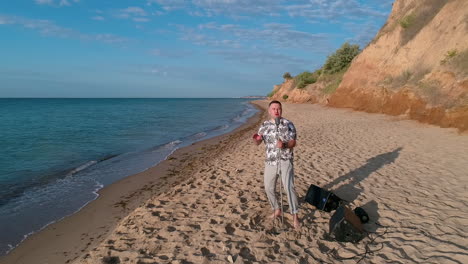 man singing into microphone outdoor. young man singing into microphone while standing on the beach
