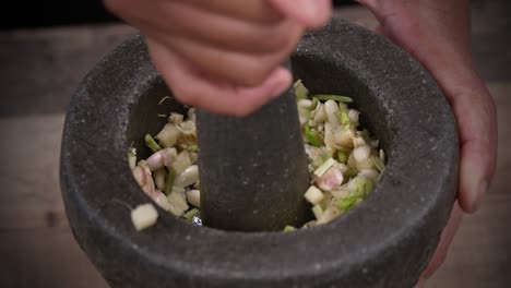 garlic herbs and chilly making curry paste from scratch with mortar and pestle, stone mortar making fresh paste by hand