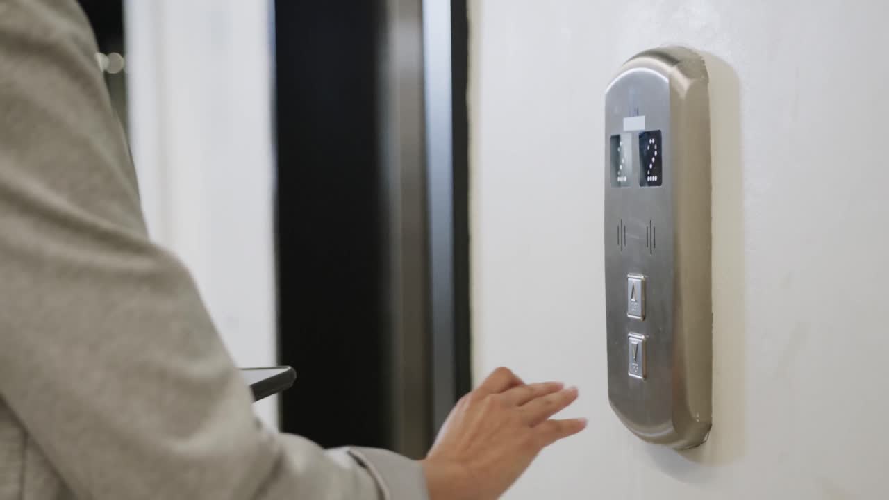 사무실에서 스마트폰과 엘리베이터를 사용하는 두 인종의 사업가 여성의 중간 섹션, 느린 동작