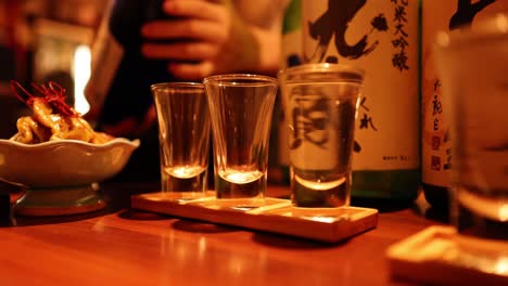 sequential pouring of sake into glasses