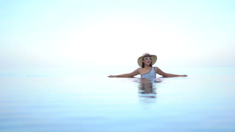 Paraíso-Como-Paisaje-Mujer-Exótica-En-La-Piscina-Infinita-Con-Un-Horizonte-Sin-Fin-Brillante-En-El-Fondo,-Marco-Completo