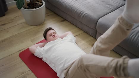 Portrait-of-a-guy-with-down-syndrome-doing-home-workouts-on-the-floor