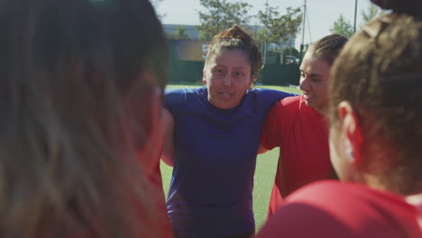 Manager-Joining-Hands-With-Womens-Soccer-Team-During-Motivational-Pep-Talk-Before-Match